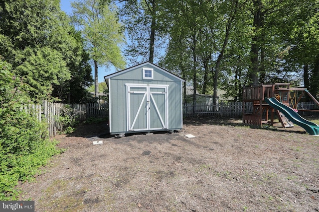 view of shed featuring a fenced backyard and a playground