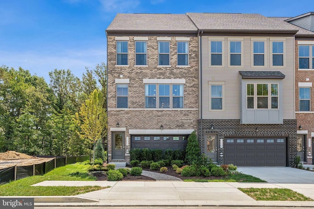 townhome / multi-family property with concrete driveway, brick siding, an attached garage, and fence