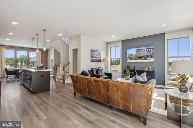 living area with stairway, baseboards, recessed lighting, and wood finished floors