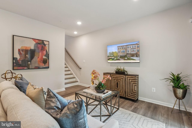 living room featuring baseboards, recessed lighting, wood finished floors, and stairway
