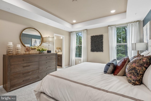 bedroom with a raised ceiling, baseboards, ensuite bathroom, carpet, and recessed lighting
