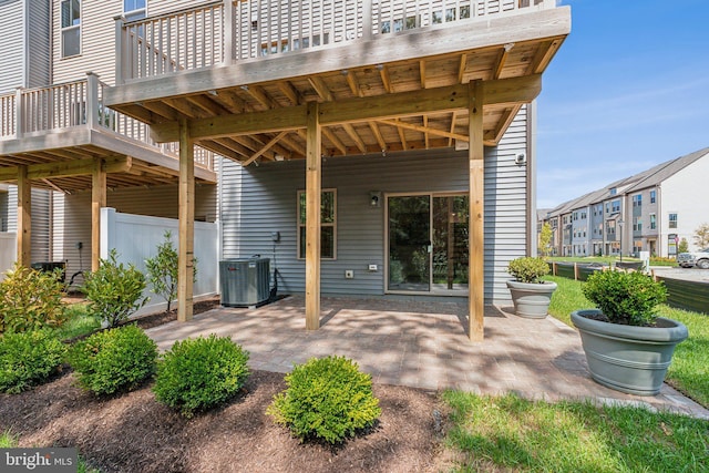 rear view of house with a patio, fence, and central AC unit