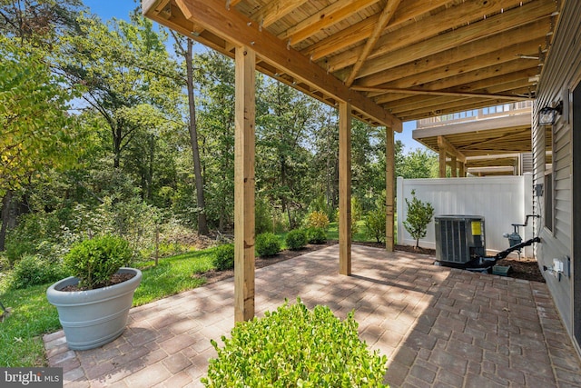 view of patio with central air condition unit and fence