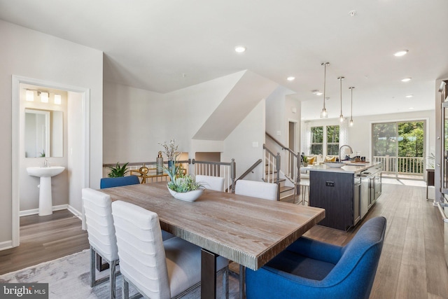 dining space with baseboards, recessed lighting, stairs, and wood finished floors