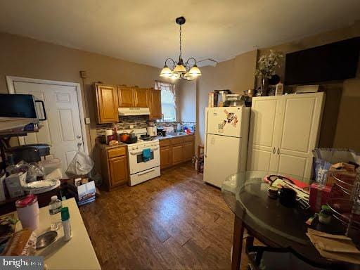 807 Spruce St, Camden, NJ 08103 - kitchen with pendant lighting, dark wood finished floors, white appliances, under cabinet range hood, and a chandelier