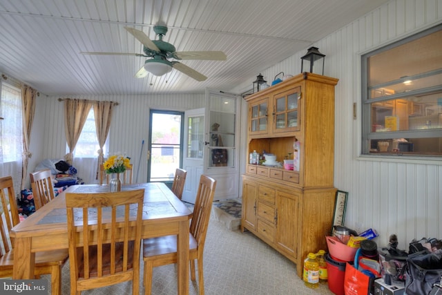 dining space with ceiling fan and light colored carpet