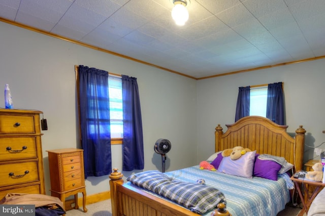 bedroom with crown molding and carpet flooring