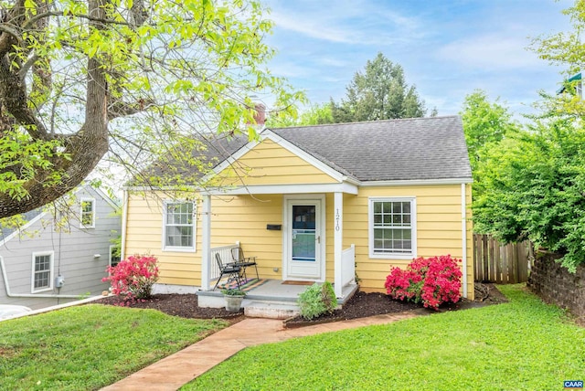 1210 Meriwether St, Charlottesville, VA 22902 - bungalow-style house featuring a chimney, a shingled roof, fence, and a front yard