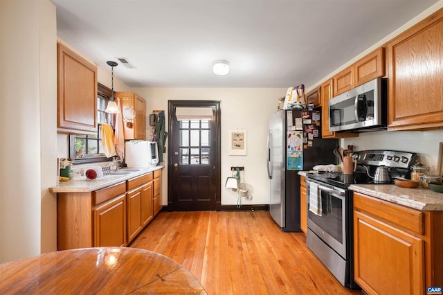 1210 Meriwether St, Charlottesville, VA 22902 - kitchen featuring light countertops, appliances with stainless steel finishes, plenty of natural light, and light wood-style floors