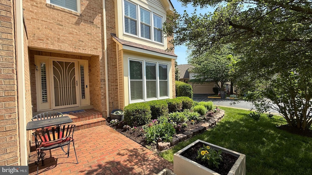 property entrance with brick siding and a yard