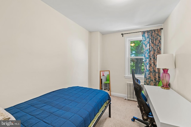 bedroom featuring light colored carpet, radiator heating unit, baseboards, and an office area
