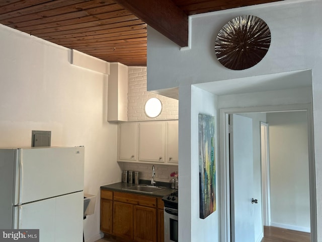 7401 18th Ave Unit 208, Hyattsville, MD 20783 - kitchen with dark countertops, a sink, freestanding refrigerator, tasteful backsplash, and wood ceiling