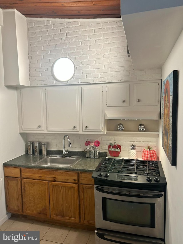7401 18th Ave Unit 208, Hyattsville, MD 20783 - kitchen with dark countertops, a sink, brown cabinetry, stainless steel range with gas cooktop, and light tile patterned floors