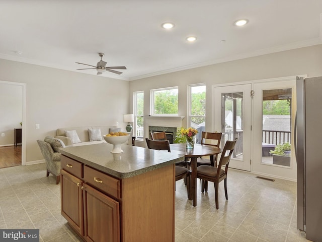 29 Norwood Ln, Fredericksburg, VA 22406 - kitchen with ceiling fan, a kitchen island, crown molding, freestanding refrigerator, and a glass covered fireplace