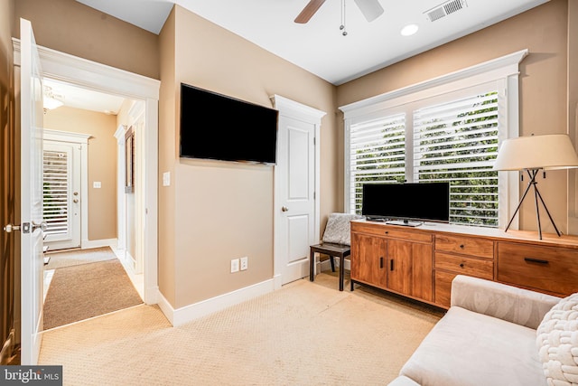 living room with ceiling fan, carpet, and baseboards
