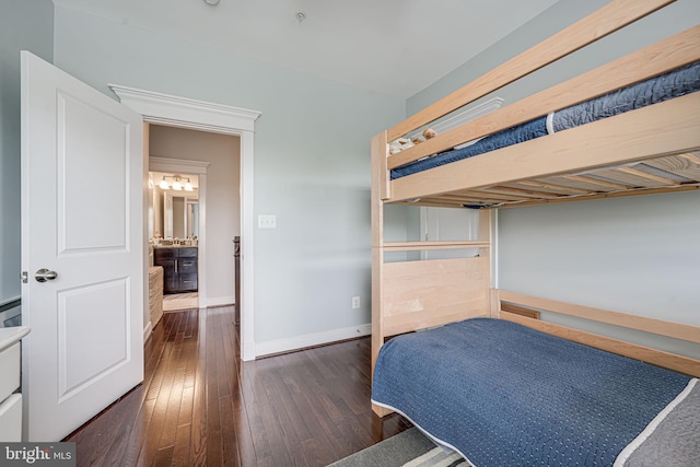 bedroom with dark wood-type flooring and baseboards