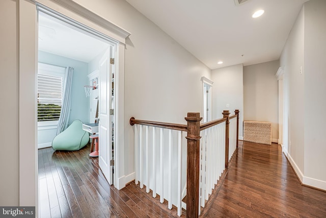 hall featuring hardwood / wood-style floors, an upstairs landing, baseboards, and recessed lighting
