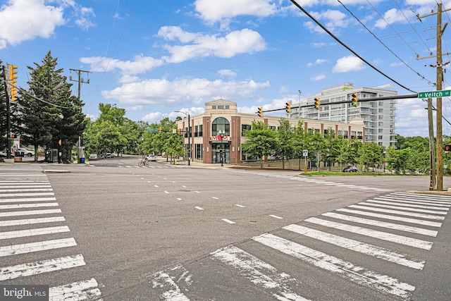 view of asphalt street featuring traffic lights, street lighting, and traffic signs