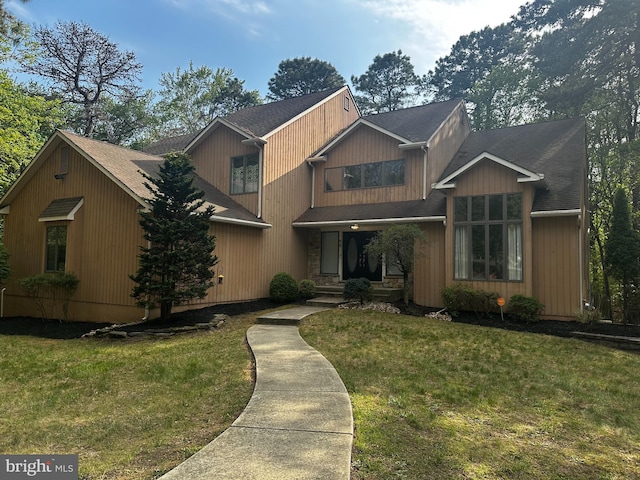 view of front of home with a front lawn and a shingled roof