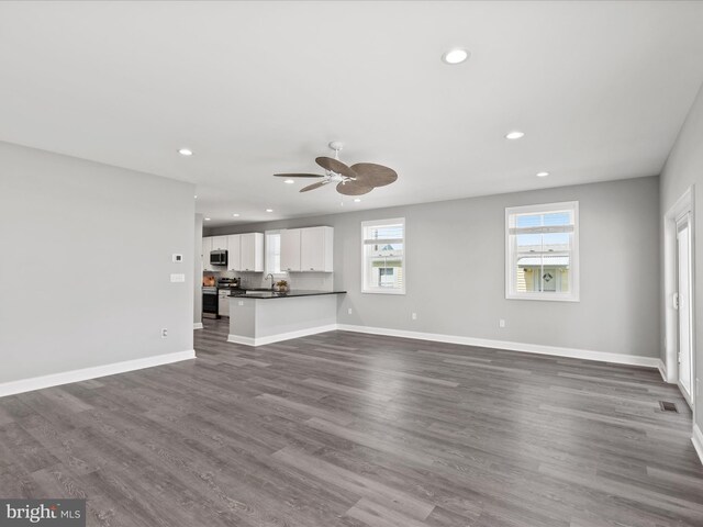 36986 Blue Teal Rd, Selbyville, DE 19975 - unfurnished living room featuring dark wood-style flooring, recessed lighting, ceiling fan, and a sink