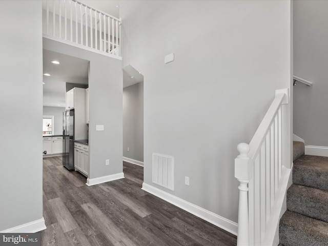 36986 Blue Teal Rd, Selbyville, DE 19975 - stairway with baseboards, a towering ceiling, wood finished floors, and visible vents