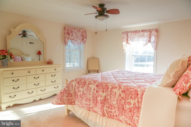 bedroom featuring light colored carpet and a ceiling fan