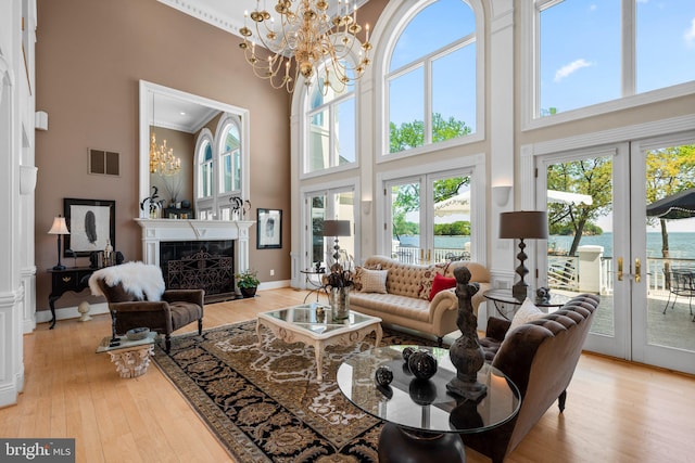 285 Eagle Hill Rd, Pasadena, MD 21122 - living area featuring light wood finished floors, a chandelier, french doors, a towering ceiling, and visible vents