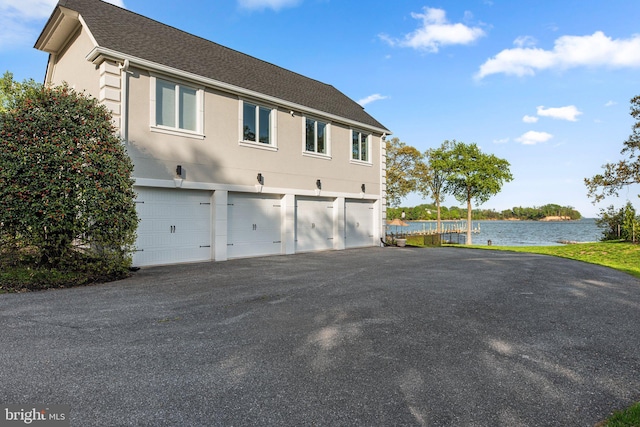 285 Eagle Hill Rd, Pasadena, MD 21122 - view of side of property featuring a shingled roof, an attached garage, aphalt driveway, stucco siding, and a water view