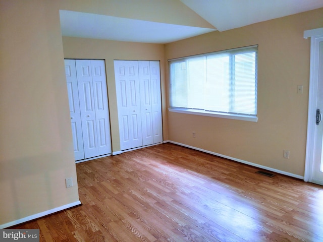 18478 Stone Holw, Germantown, MD 20874 - unfurnished bedroom featuring baseboards, multiple closets, visible vents, and wood finished floors
