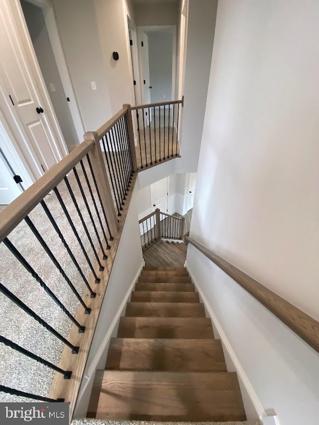 stairway featuring baseboards and wood finished floors