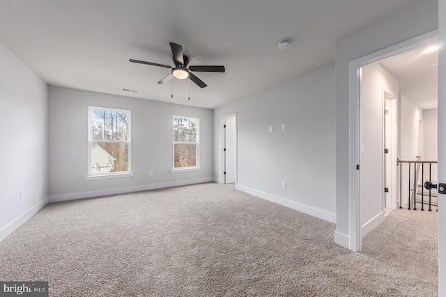 spare room featuring ceiling fan, visible vents, baseboards, and carpet
