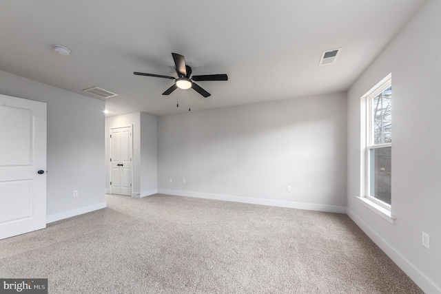 spare room with ceiling fan, visible vents, and carpet