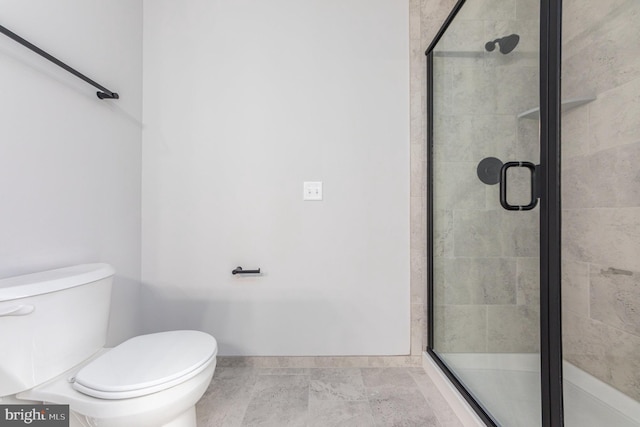 full bathroom with toilet, baseboards, and a stall shower