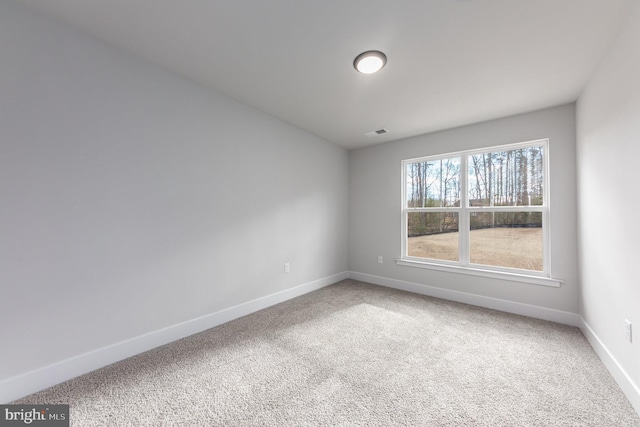 carpeted spare room with baseboards and visible vents