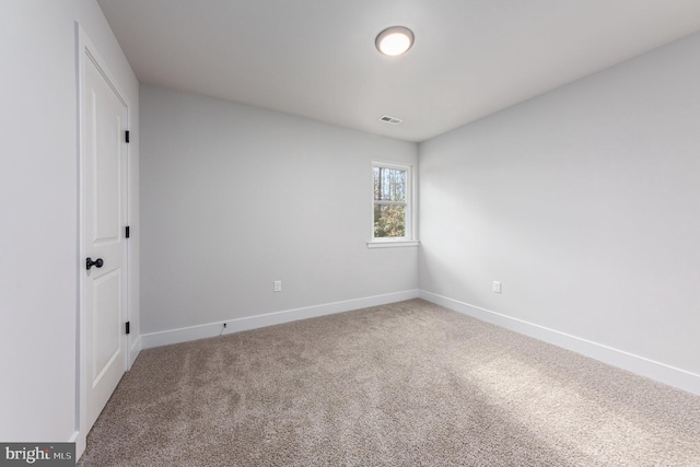 unfurnished room with carpet floors, baseboards, and visible vents