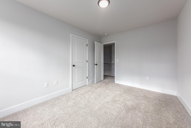 unfurnished bedroom featuring baseboards and carpet