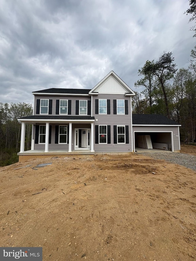 view of front facade featuring a garage, dirt driveway, and covered porch
