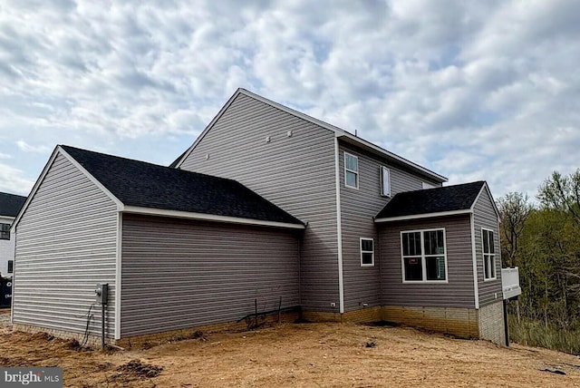 rear view of house featuring a shingled roof