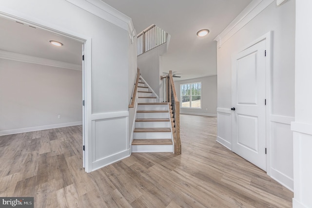 staircase with crown molding, baseboards, recessed lighting, and wood finished floors