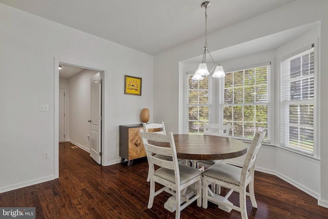 dining area featuring an inviting chandelier, baseboards, and wood finished floors