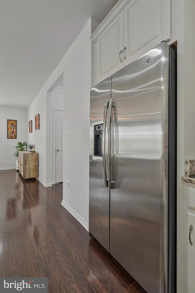 kitchen featuring white cabinets, baseboards, stainless steel fridge, and dark wood-type flooring