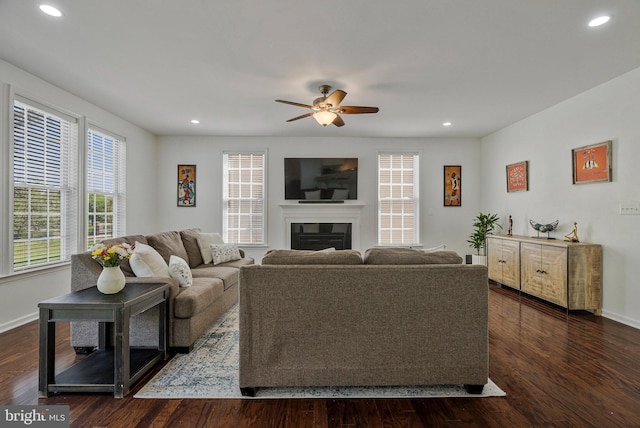 living room with a glass covered fireplace, baseboards, ceiling fan, and recessed lighting