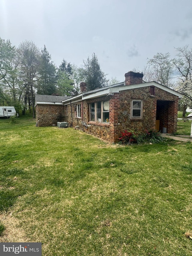 rear view of property with a lawn and a chimney