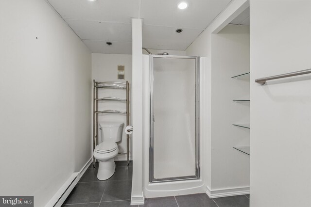 bathroom with tile patterned floors, toilet, and a shower stall