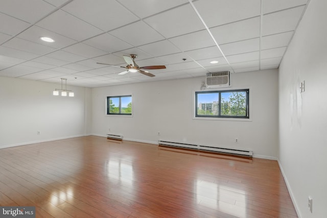 spare room featuring wood finished floors, a healthy amount of sunlight, baseboard heating, and a baseboard radiator