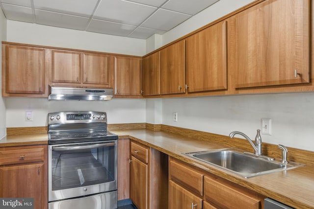 kitchen with a sink, under cabinet range hood, brown cabinets, and stainless steel electric range oven