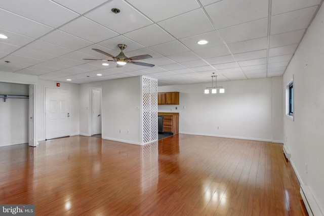 unfurnished living room featuring ceiling fan, light wood-type flooring, baseboards, a baseboard heating unit, and recessed lighting
