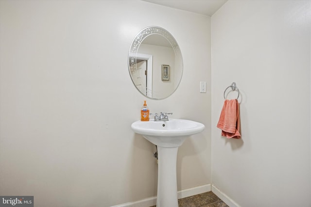 bathroom featuring baseboards and a sink