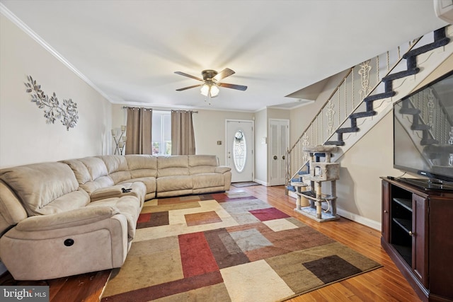 living room featuring stairway, ornamental molding, and ceiling fan