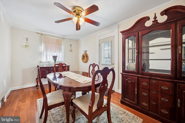 dining space featuring light wood-style floors, baseboards, ornamental molding, and ceiling fan